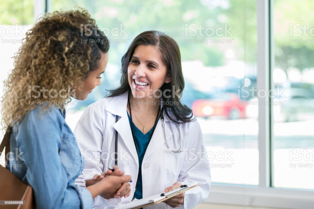 Una doctora que consulta con un paciente.