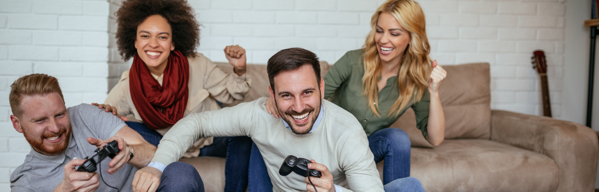 Cuatro adultos reunidos jugando a un videojuego