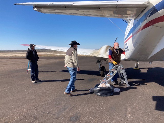 Ground operators loading aircraft for baiting mission.