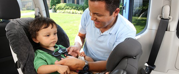 Child being buckled in a car seat.