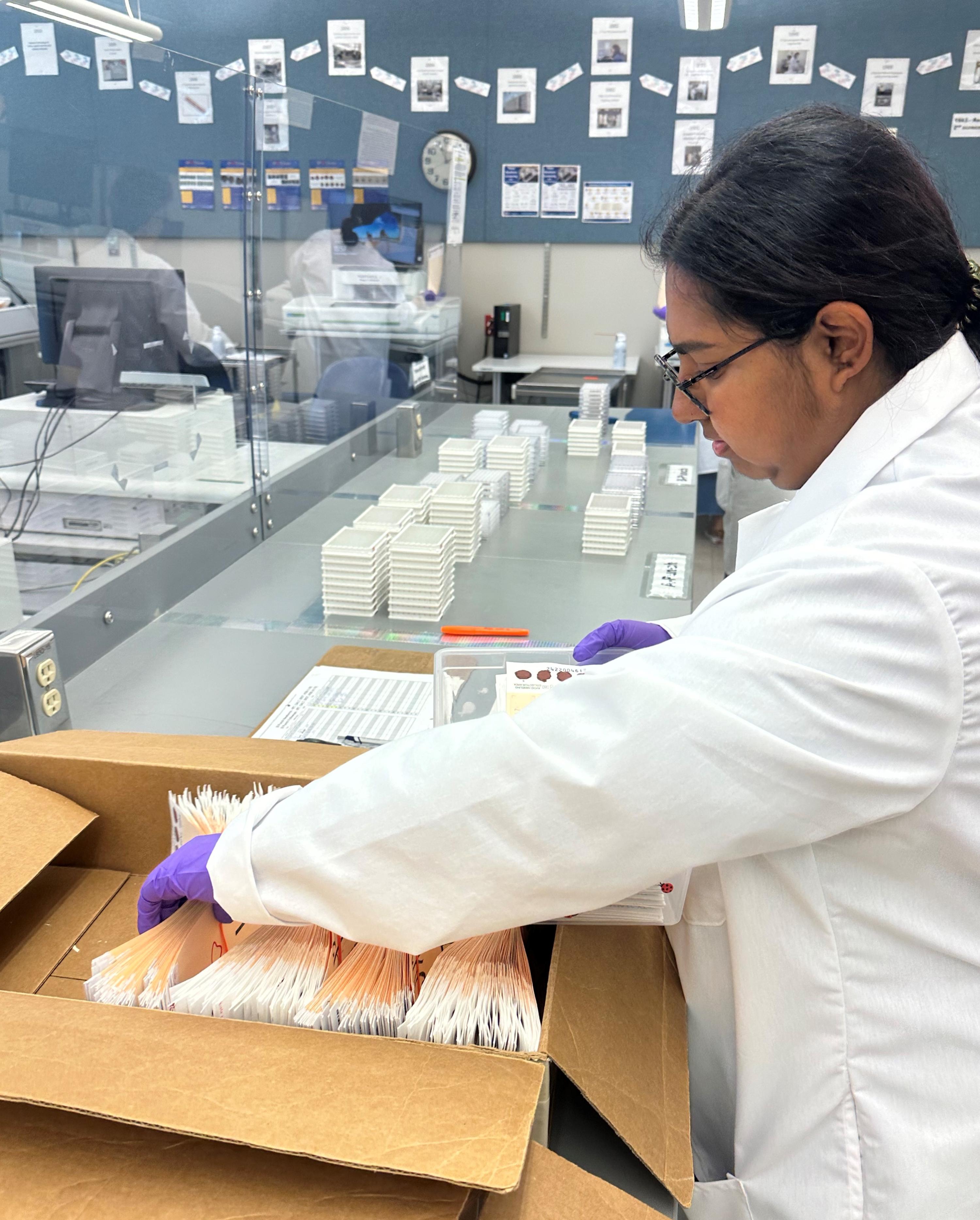 Lab Technician placing specimens in a box 