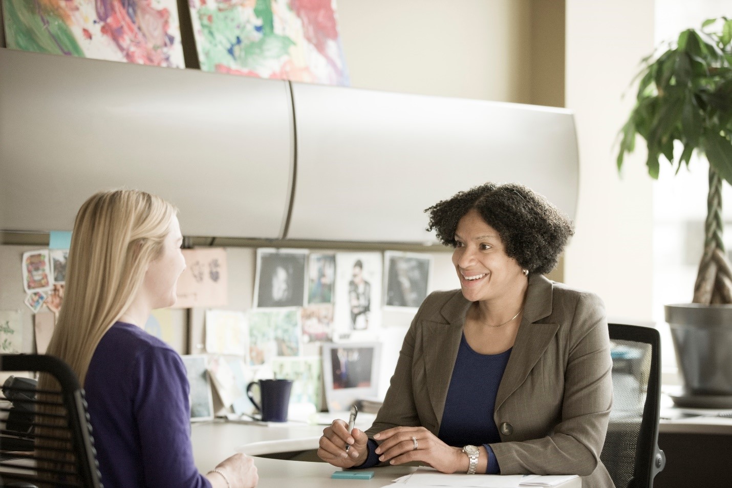 Two women in an office talking. 